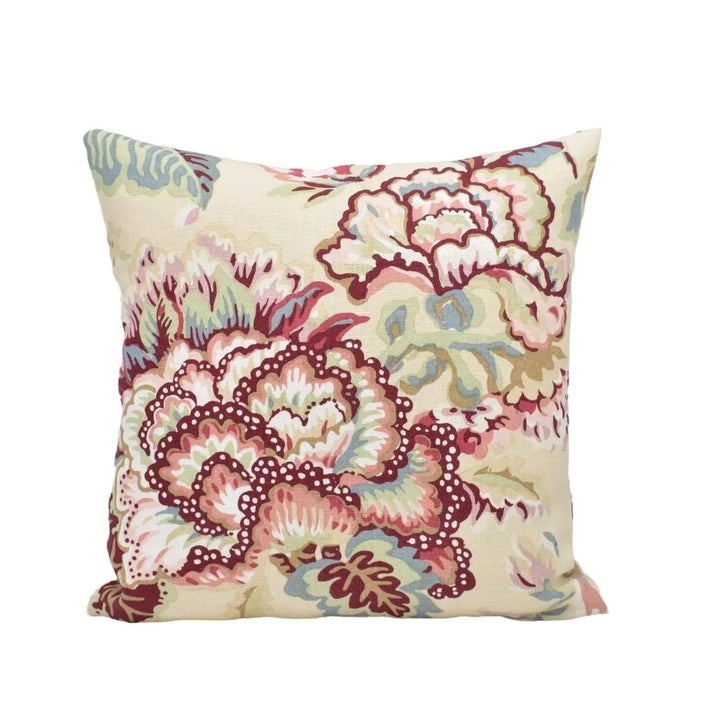 A decorative throw pillow with a floral pattern in shades of pink, red, and green.