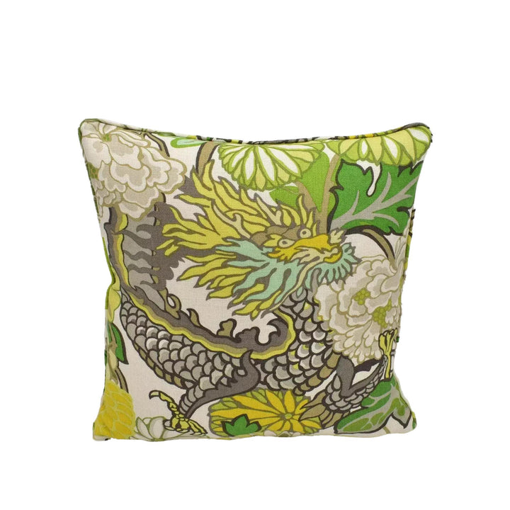 A decorative throw pillow with a vibrant dragon design in shades of green, yellow, and white.
