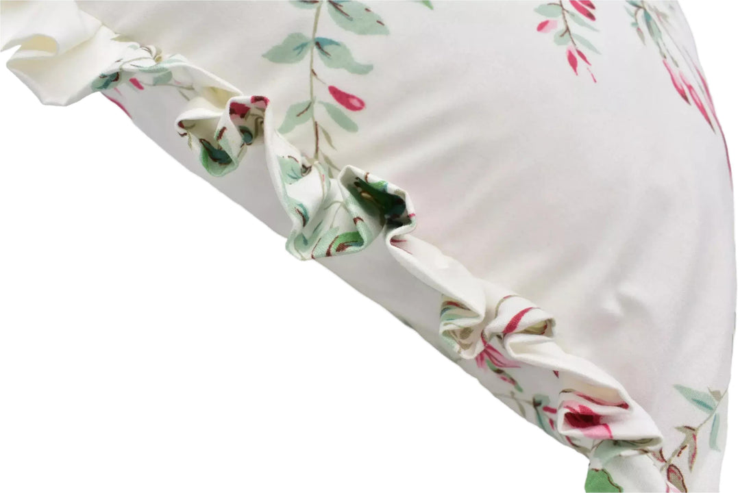 a close-up view of a white fabric with a floral pattern, featuring a ruffled edge and a delicate design.