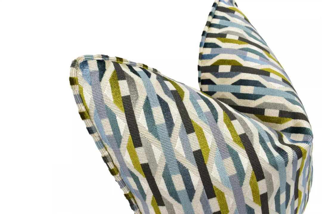 a close-up view of a colorful, geometric-patterned pillow or cushion with a mix of blue, green, and gray colors.