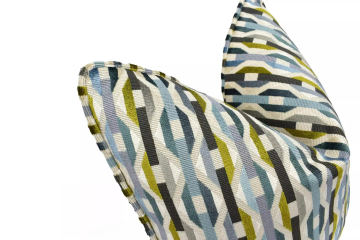 a close-up view of a colorful, geometric-patterned pillow or cushion with a mix of blue, green, and gray colors.