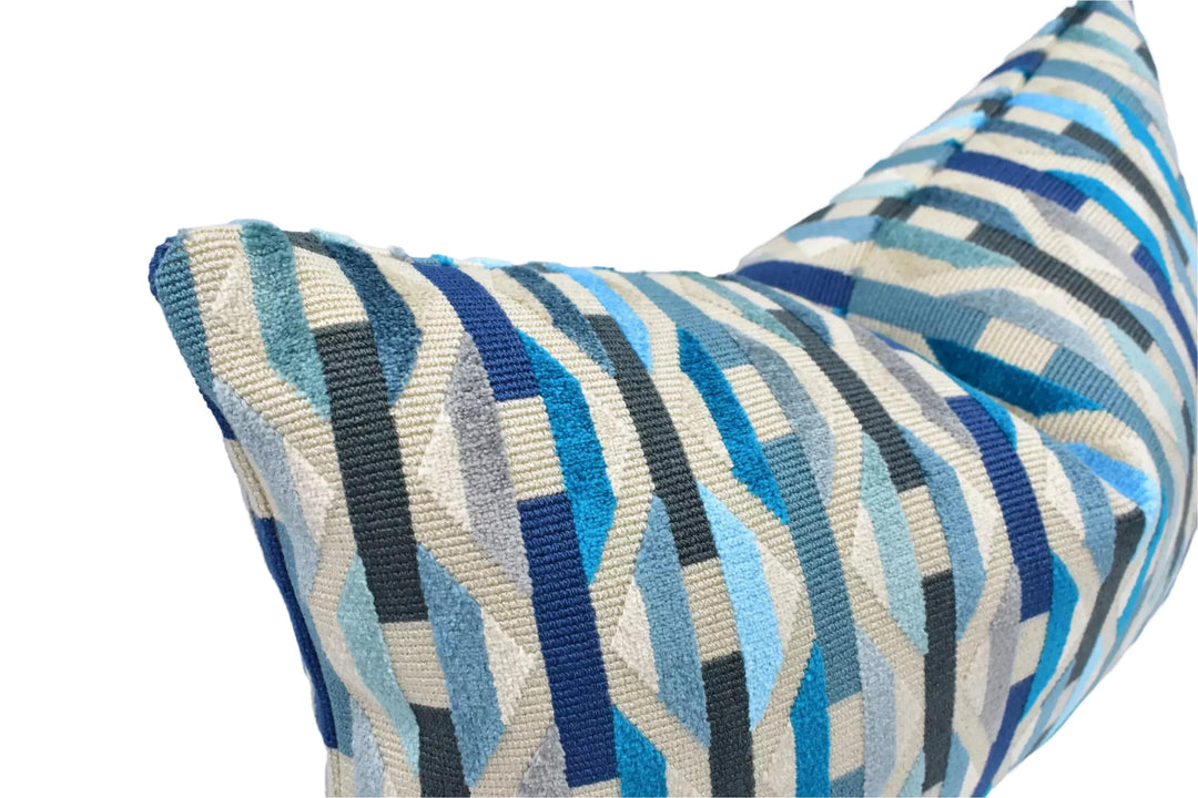A close-up view of a decorative pillow with a geometric pattern in shades of blue and gray.