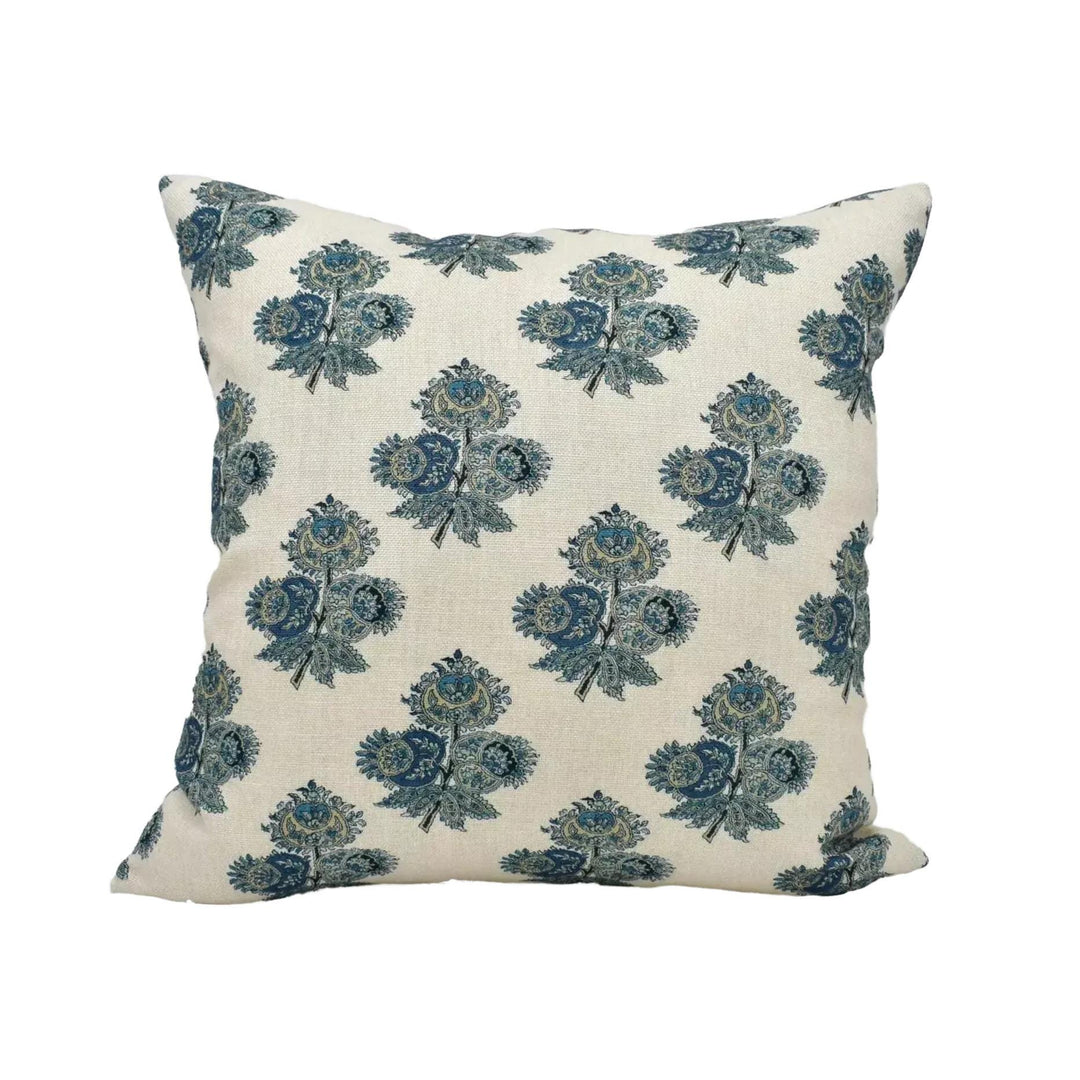 A square throw pillow with a repeating floral pattern in shades of blue and green.