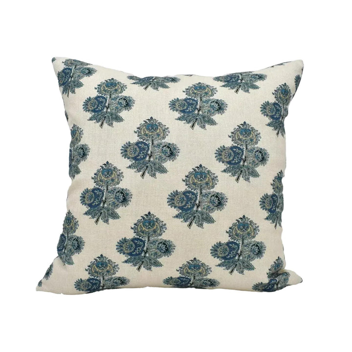 A square throw pillow with a repeating floral pattern in shades of blue and green.