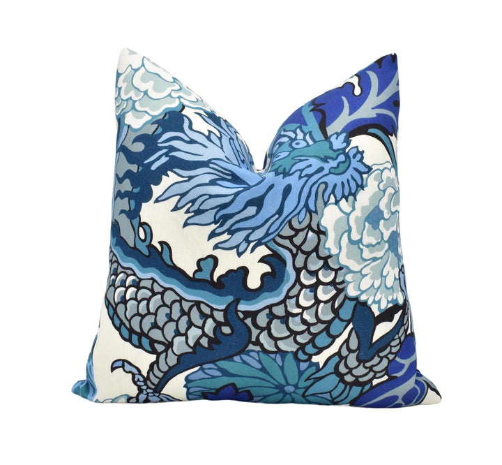 A decorative pillow with a blue and white dragon design.