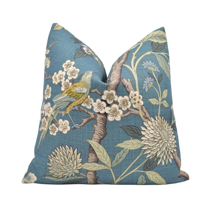 a blue pillow with a bird and flowers on it