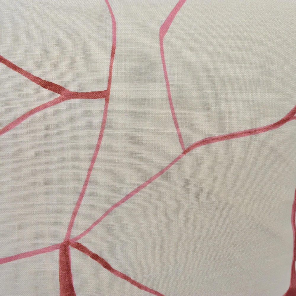 a close-up view of a fabric with a pink and white abstract pattern. The pattern consists of intersecting lines and curves, creating a visually striking design.