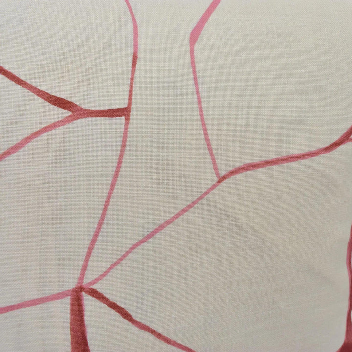 a close-up view of a fabric with a pink and white abstract pattern. The pattern consists of intersecting lines and curves, creating a visually striking design.