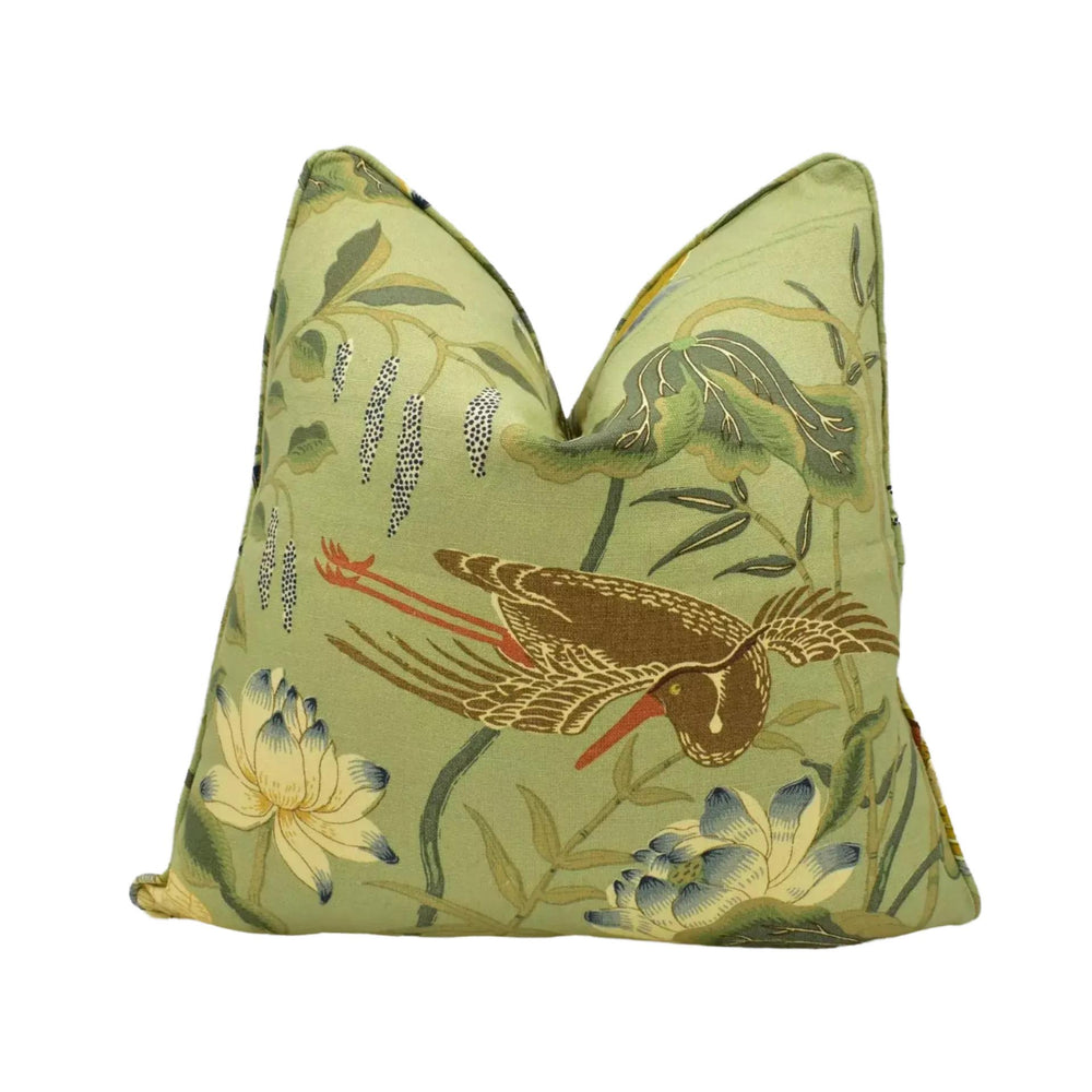 a decorative pillow with a vibrant green color and a detailed floral and bird motif.