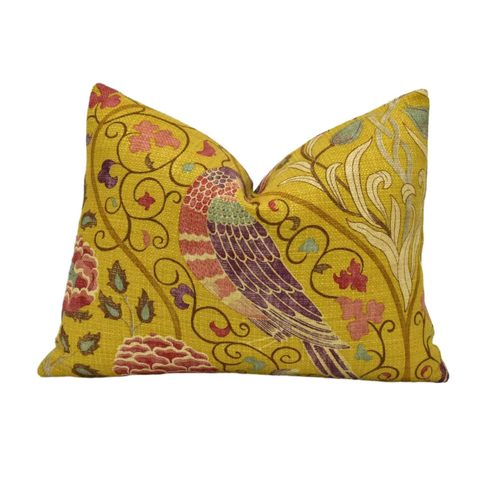 a vibrant yellow pillow with a detailed floral and bird motif.