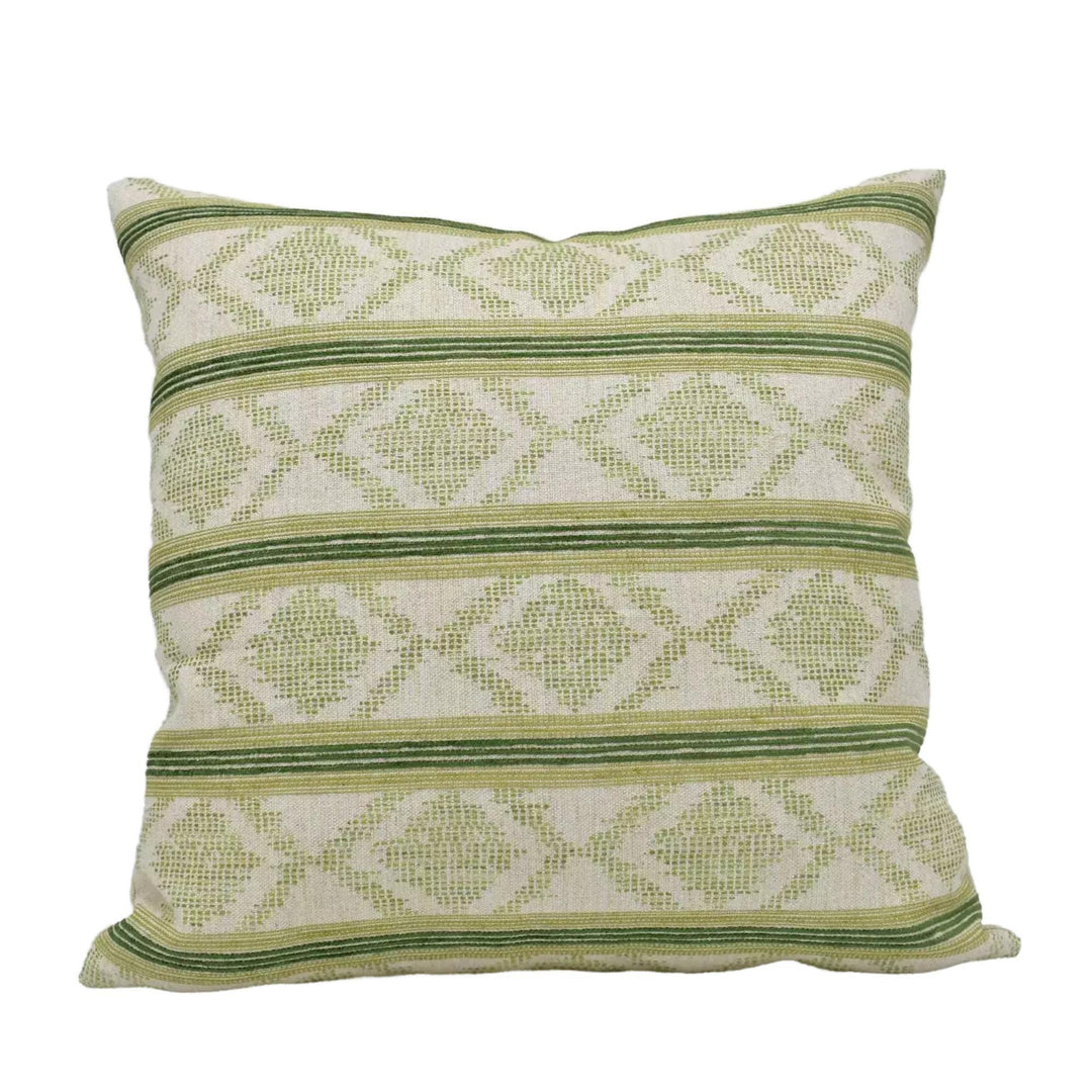 A square throw pillow with a repeating pattern of green and white diamond shapes.