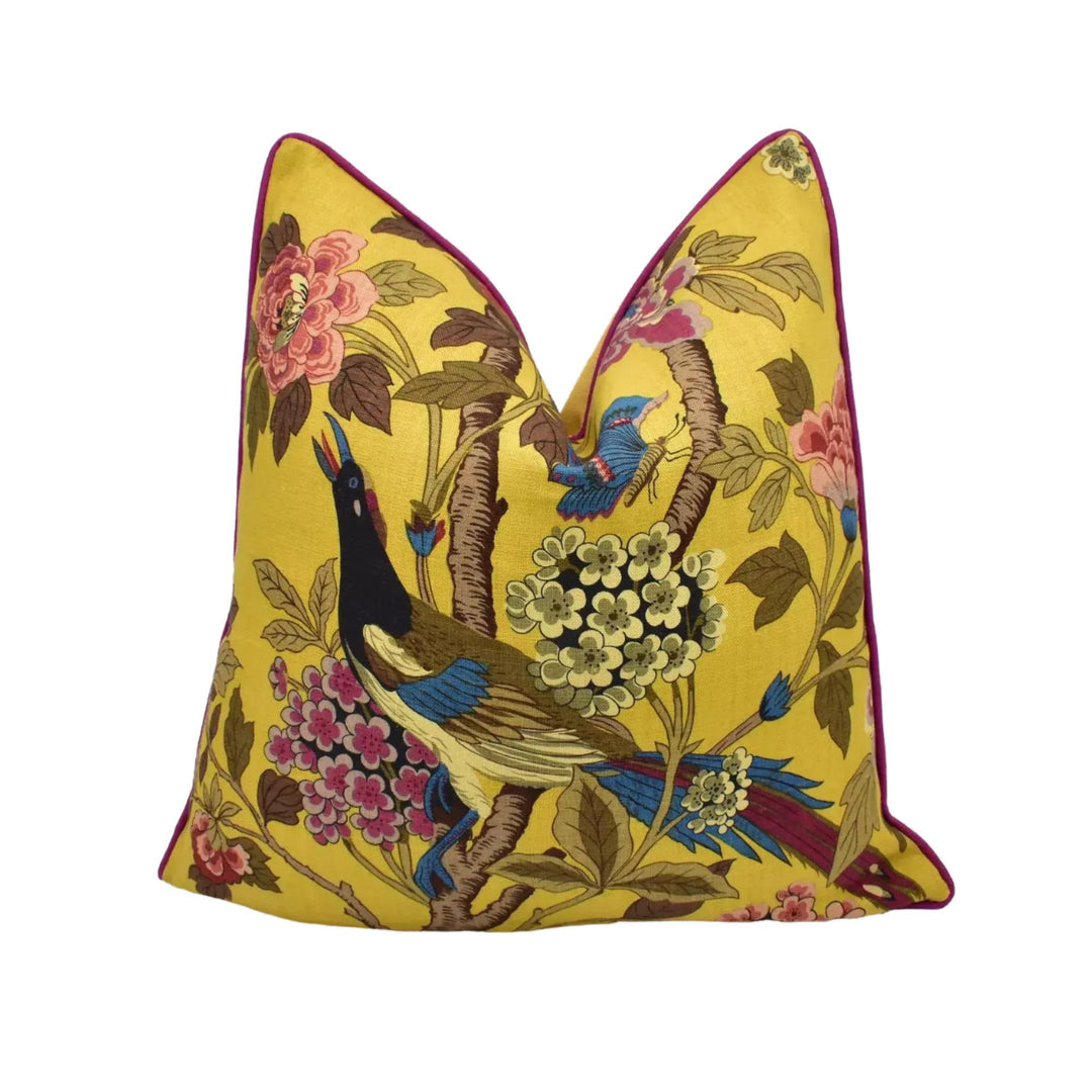 A yellow pillow with a vibrant floral and bird design.