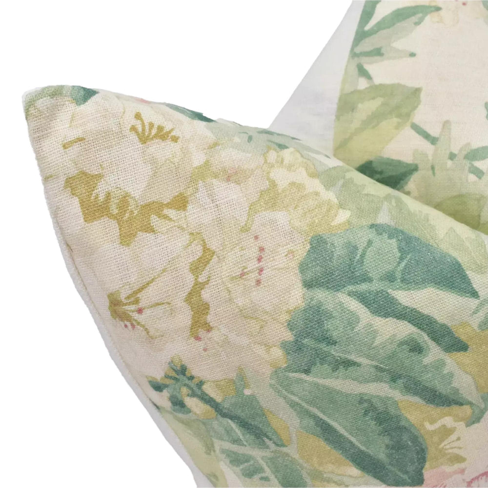 a close-up view of a decorative pillow with a floral pattern in shades of green and white.