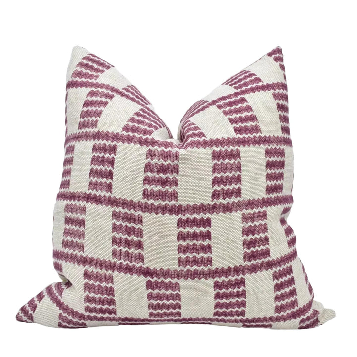 A single pillow with a checkered pattern in shades of pink and white.