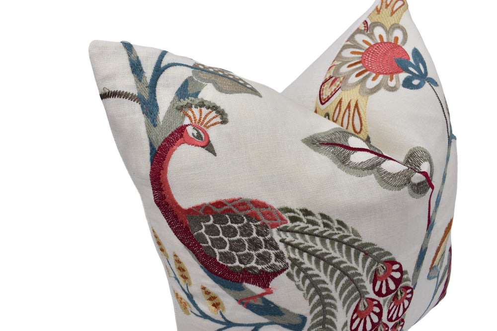 a decorative pillow with a peacock design, featuring a colorful and intricate pattern of flowers, leaves, and feathers.