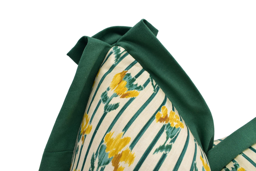a close-up view of a green and yellow floral patterned fabric, with a green trim around the edges.