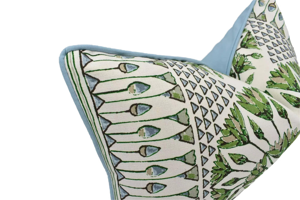 a close-up view of a decorative pillow with a repeating pattern of green and white geometric shapes.