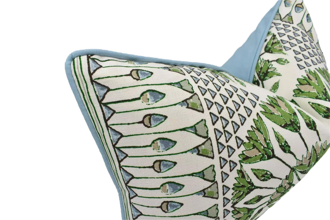 a close-up view of a decorative pillow with a repeating pattern of green and white geometric shapes.