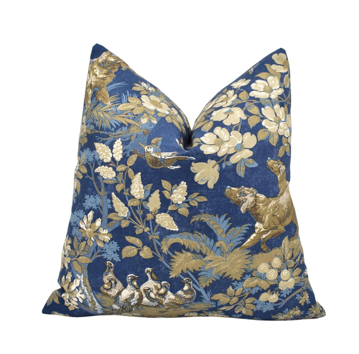 a blue and gold floral patterned pillow with a lion and birds on it.