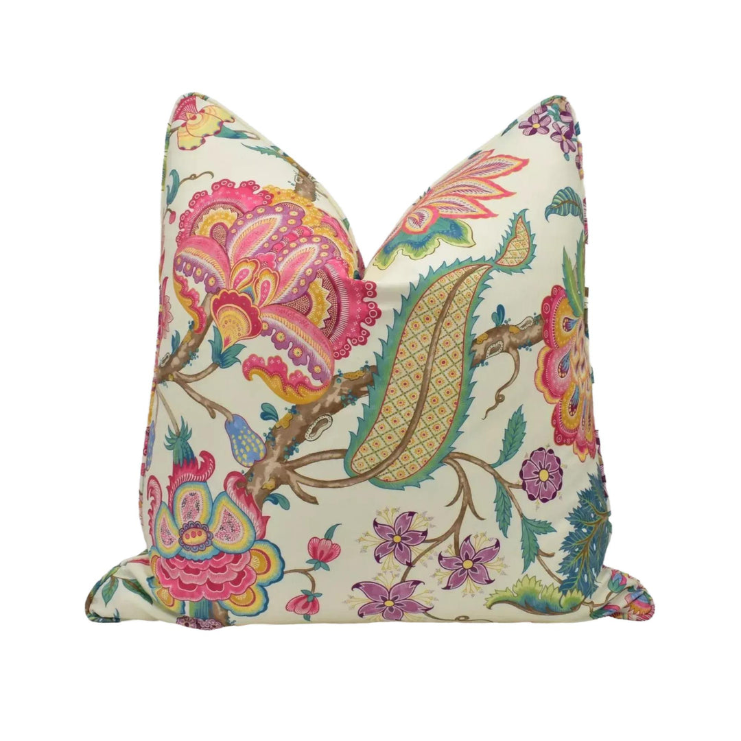 a decorative pillow with a vibrant floral pattern in shades of pink, green, yellow, and blue.