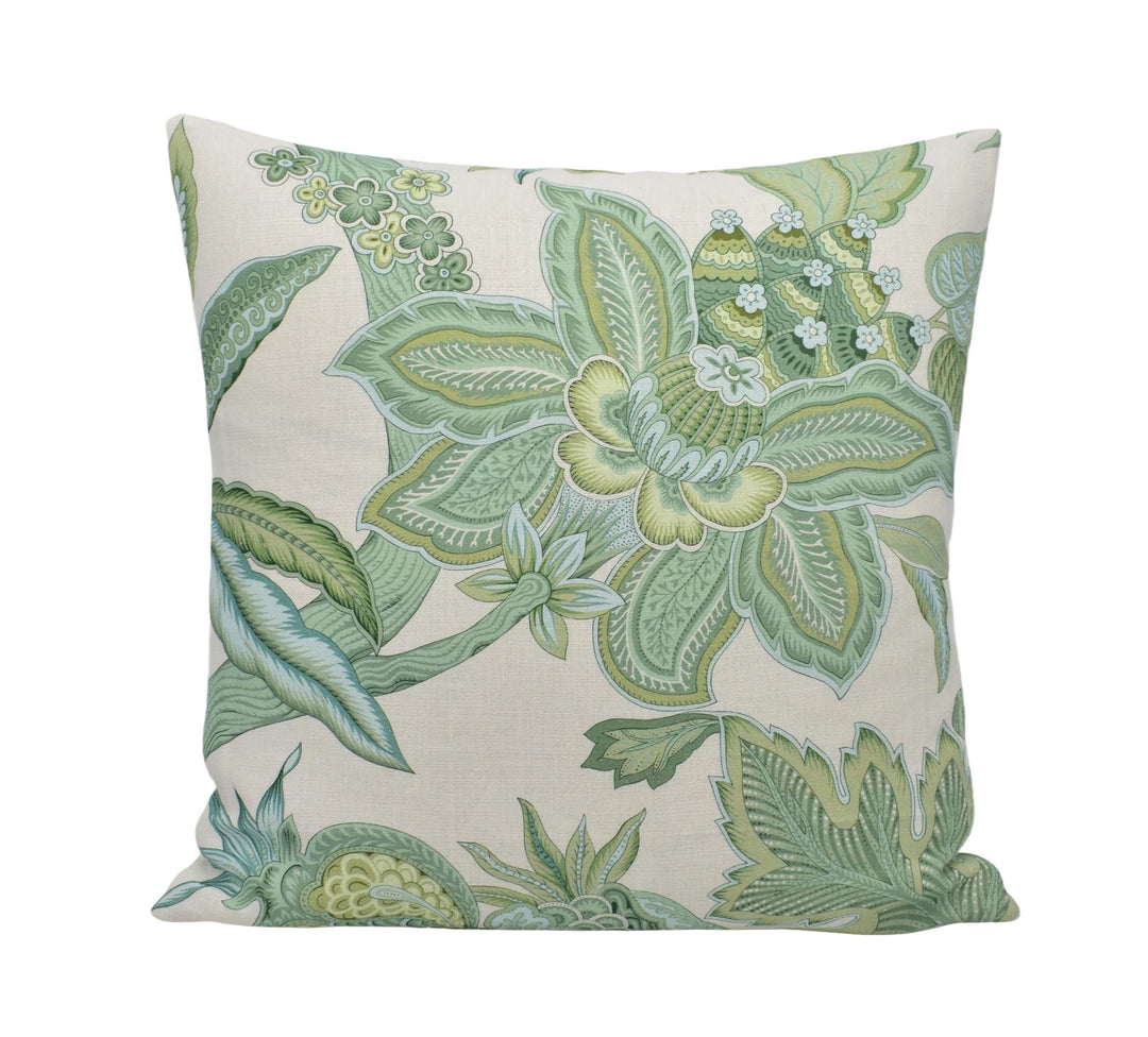 a green and white pillow on a white background