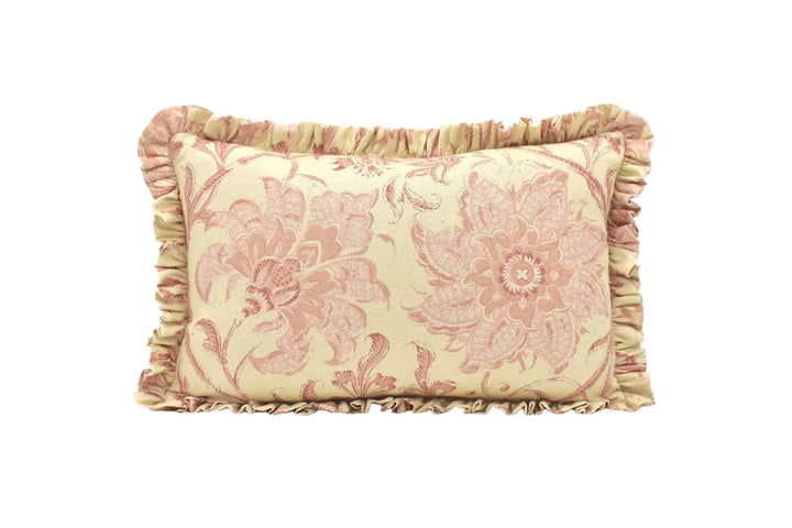 A decorative pillow with a floral pattern in shades of pink and yellow, featuring a ruffled trim around the edges.