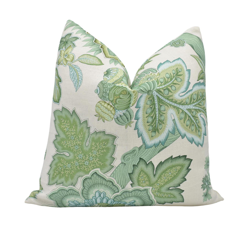 a green and white pillow on a white background
