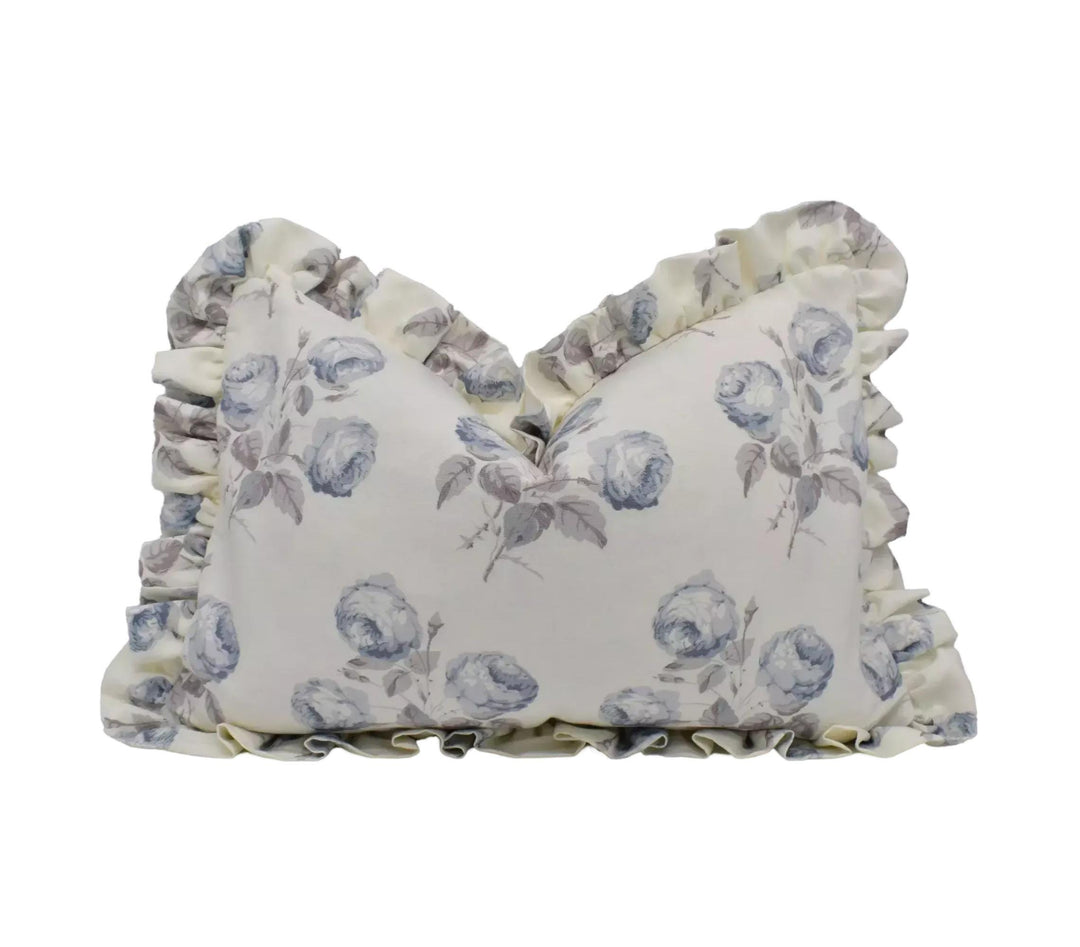 A decorative pillow with a floral pattern and ruffled edges.