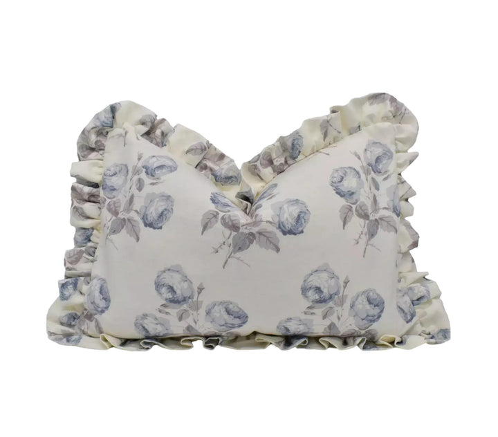 A decorative pillow with a floral pattern and ruffled edges.
