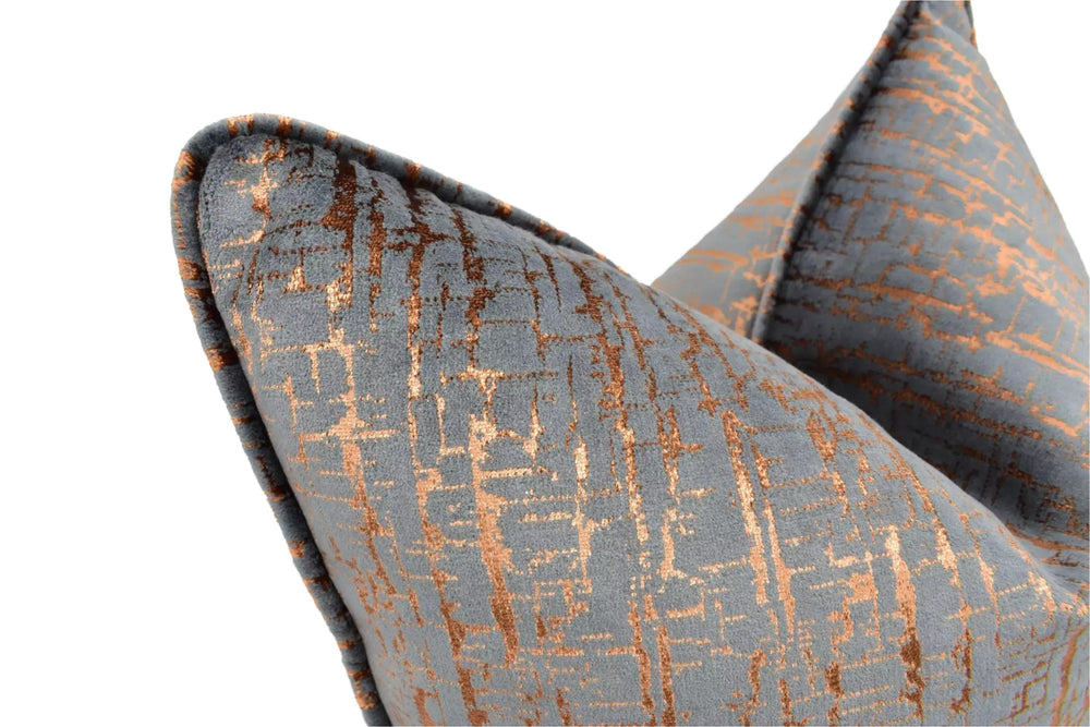 a close-up view of a gray and orange patterned pillow, with the pillow's texture and design details clearly visible.