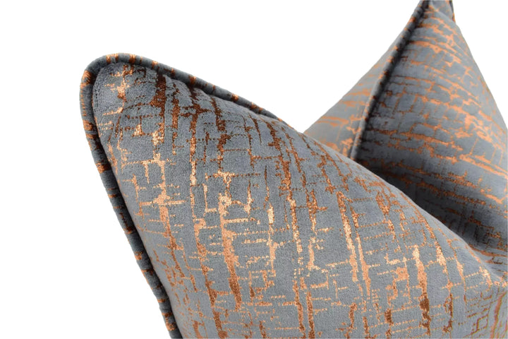 a close-up view of a gray and orange patterned pillow, with the pillow's texture and design details clearly visible.