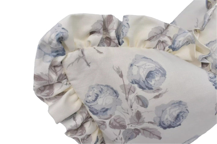 a close-up view of a fabric with a floral pattern, featuring blue and white flowers and leaves.