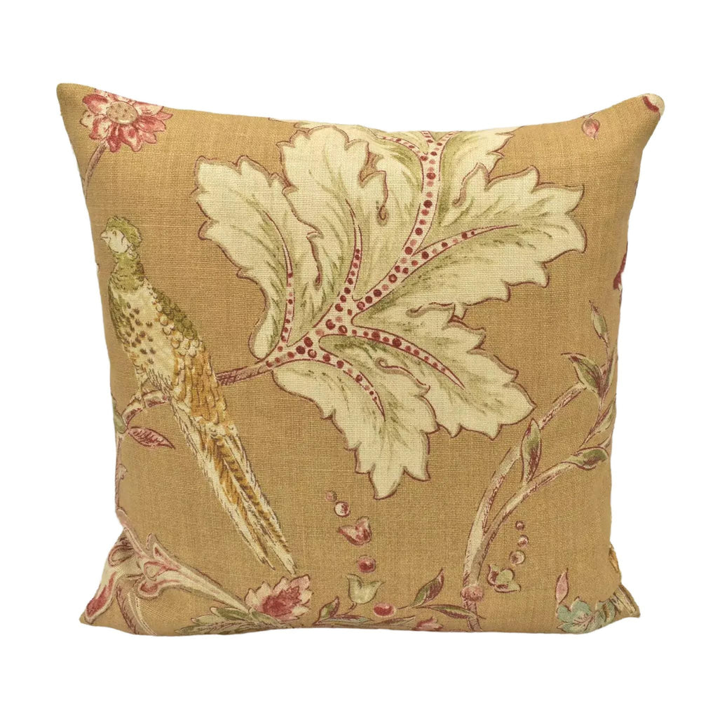 A decorative throw pillow with a floral pattern and a bird design.