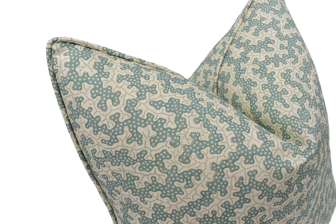 a close-up view of a decorative pillow with a pattern of small white dots on a light blue background.