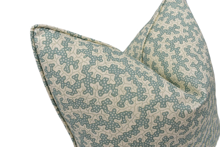 a close-up view of a decorative pillow with a pattern of small white dots on a light blue background.