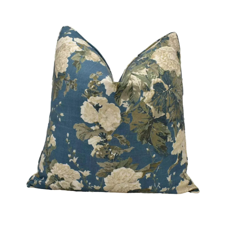 A blue and white floral print pillow with a dark blue background and white flowers.