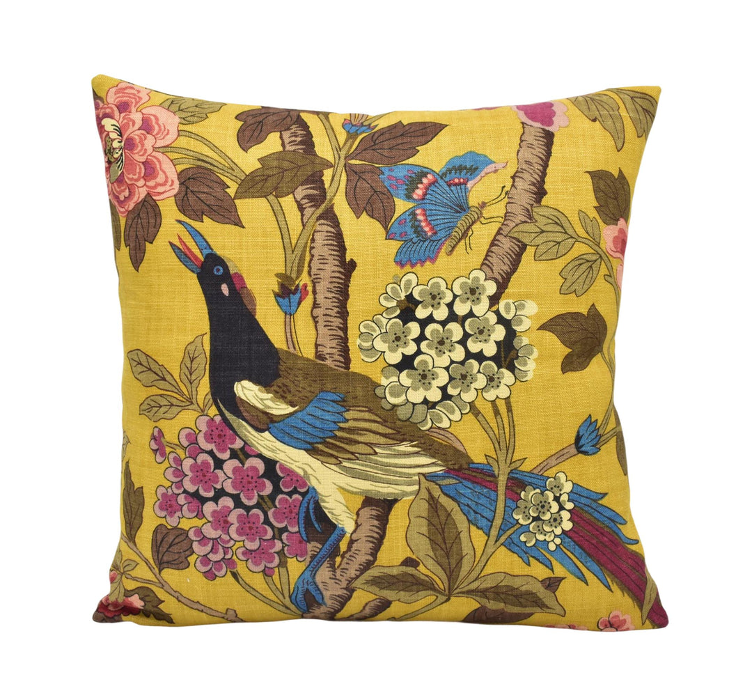a yellow pillow with a bird and flowers on it