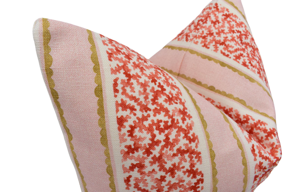 A close-up image of a decorative pillow with a floral pattern in shades of pink and red.