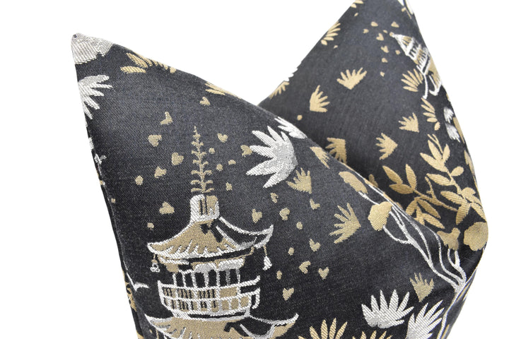 a black and gold pillow with a pagoda on it