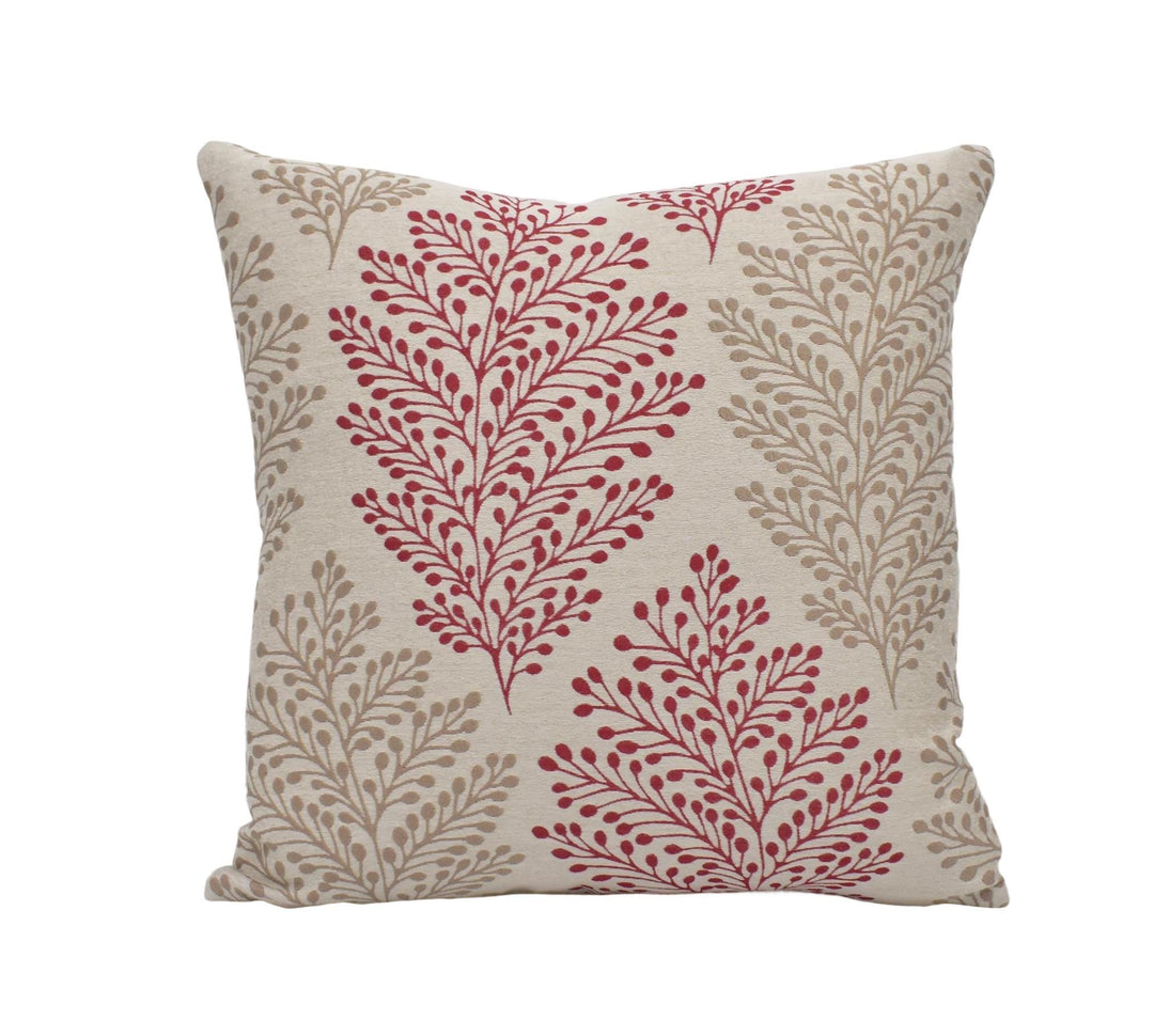 a red and beige pillow with a leaf pattern on it