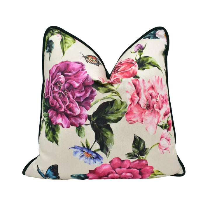 A decorative pillow with a floral print featuring pink and purple flowers, along with butterflies and leaves.