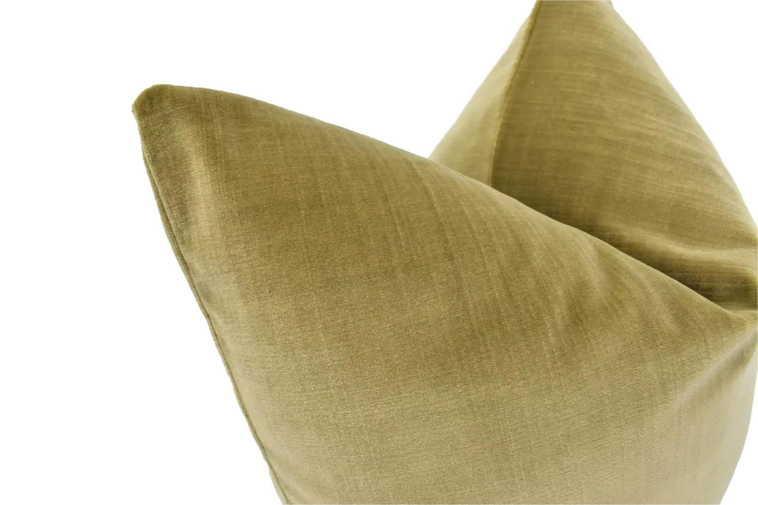 A close-up view of a beige, textured fabric, possibly a pillow or cushion, against a white background.